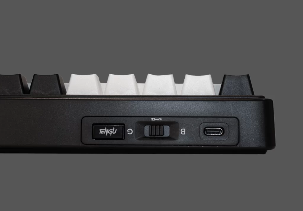 Puertos de conexión del teclado Okami EX65, vista cercana del lateral con entrada USB-C y switch de modo.