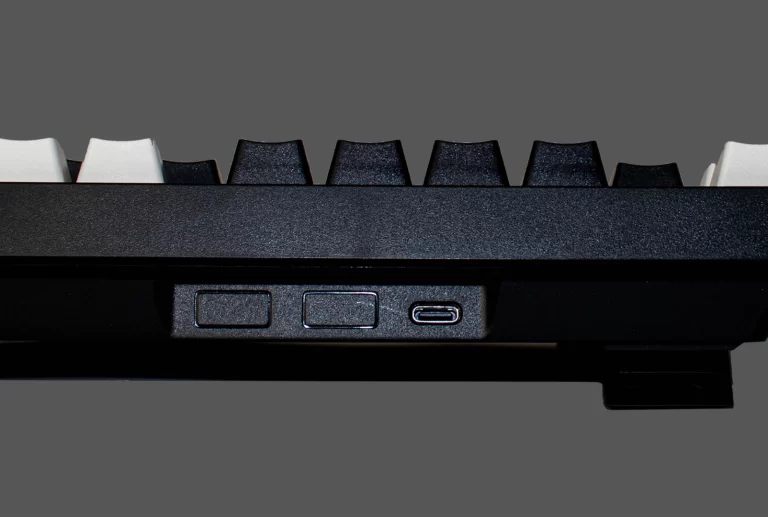 Vista trasera del teclado Yokai EX80 mostrando el puerto USB-C y los interruptores de control de modo.